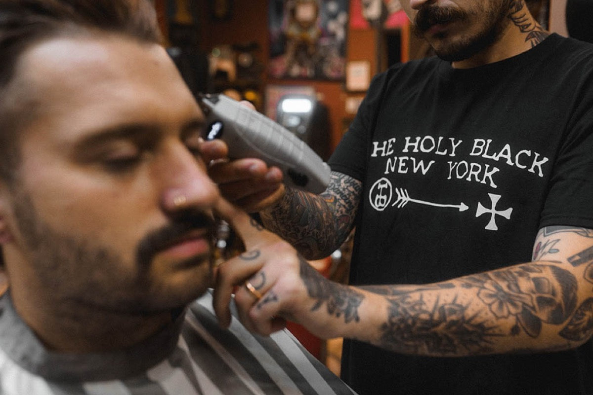Barber applying straight razor shave to client at The Holy Black Barbershop