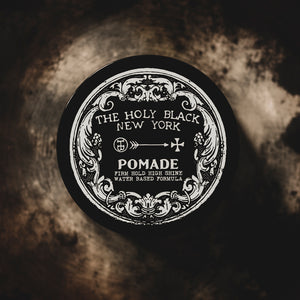 The Holy Black High Shine Pomade product shot on vintage surface