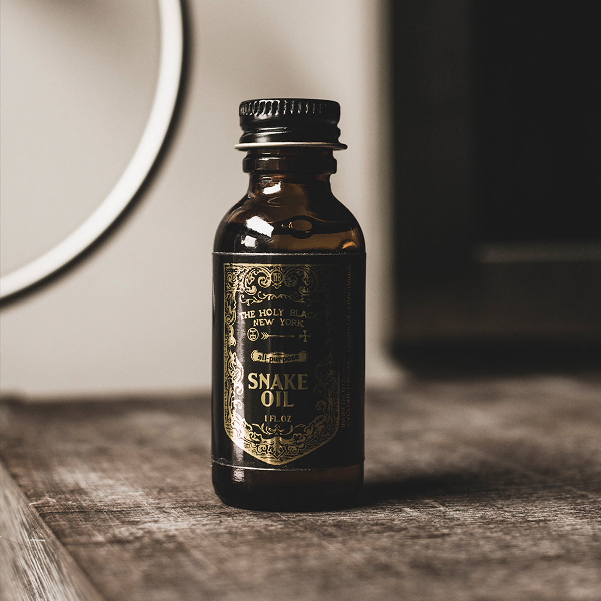 The Holy Black Snake Oil Beard Oil product shot on rustic surface